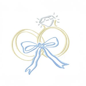 May include: An embroidered design of a diamond ring with a light blue bow. The ring is outlined in a soft yellow, and the diamond is a light blue colour. The design is on a white background.