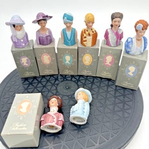 Set van 8 vintage vingerhoedjes van Avon Ladies of America uit 1984.