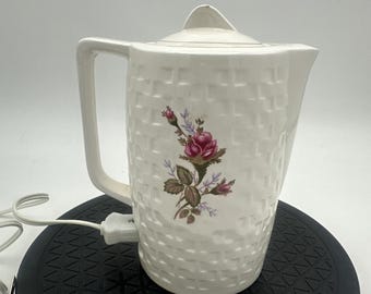 Tetera eléctrica pequeña vintage de cerámica japonesa con diseño de cesta tejida y motivos florales.