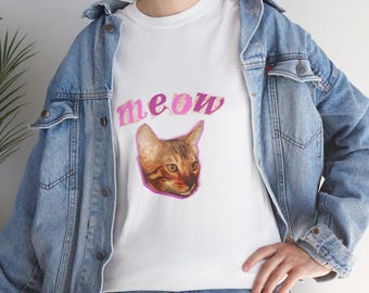 May include: White t-shirt with a pink "meow" graphic and a cat's face.