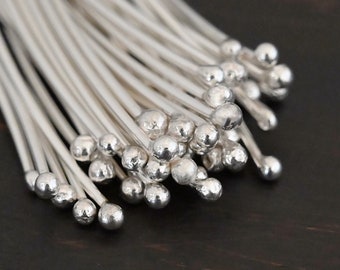 May include: A bunch of silver-colored metal sticks with round balls on the ends. The sticks are arranged in a fan shape, with the balls facing outward.