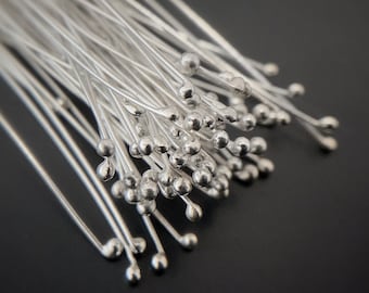 May include: A bunch of silver-colored, thin, wire-like stems with small round balls at the end. The stems are arranged in a fan shape.