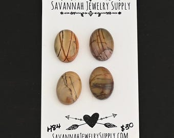 May include: Four oval-shaped, brown and white agate cabochons with a natural, marbled pattern. The cabochons are arranged in a grid on a white card with the text "SAVANNAH JEWELRY SUPPLY" at the top and "H84 SAVANNAHJEWELRYSUPPLY.COM $30" at the bottom.