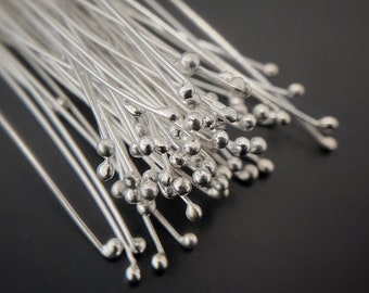 May include: A bunch of silver-toned, thin, wire-like stems with small round balls at the end. The stems are arranged in a fan shape.