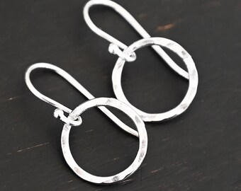 May include: A pair of silver hammered circle earrings with a simple hook closure.