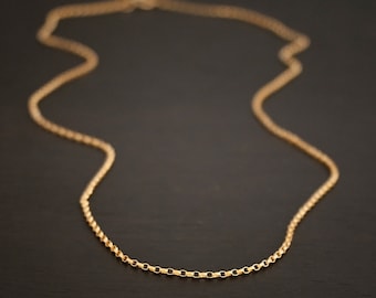 May include: A gold chain necklace with a delicate, linked design. The chain is made of small, oval-shaped links.