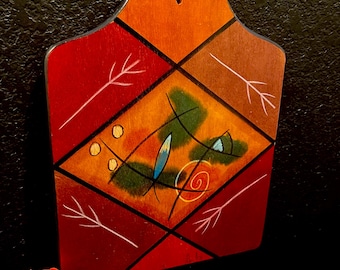 Tabla de cortar de madera artesanal Kakadu: diseño abstracto y vibrante, firmada por el artista Reut Shahar, ideal para la decoración de la pared de la cocina (34,3 cm x 25,4 cm).