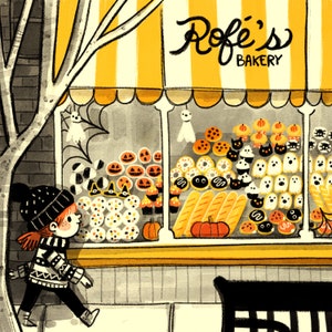 May include: A cartoon illustration of a bakery storefront called "Rofe's Bakery". The bakery window displays a variety of baked goods, including cupcakes, cookies, and bread. A young girl with red hair and a black beanie is standing in front of the bakery.