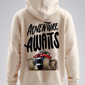 Peut inclure: Sweat &agrave; capuche beige avec un dessin d'un monster truck rouge et l'inscription noire "ADVENTURE AWAITS". Le camion a de gros pneus et se d&eacute;tache sur des &eacute;claboussures marron. Le sweat &agrave; capuche a une capuche et une coupe d&eacute;contract&eacute;e.