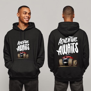 Peut inclure: Sweat &agrave; capuche noir avec l'inscription "ADVENTURE AWAITS" en blanc. Un dessin de monster truck rouge est en dessous. Le sweat est pr&eacute;sent&eacute; de face et de dos.