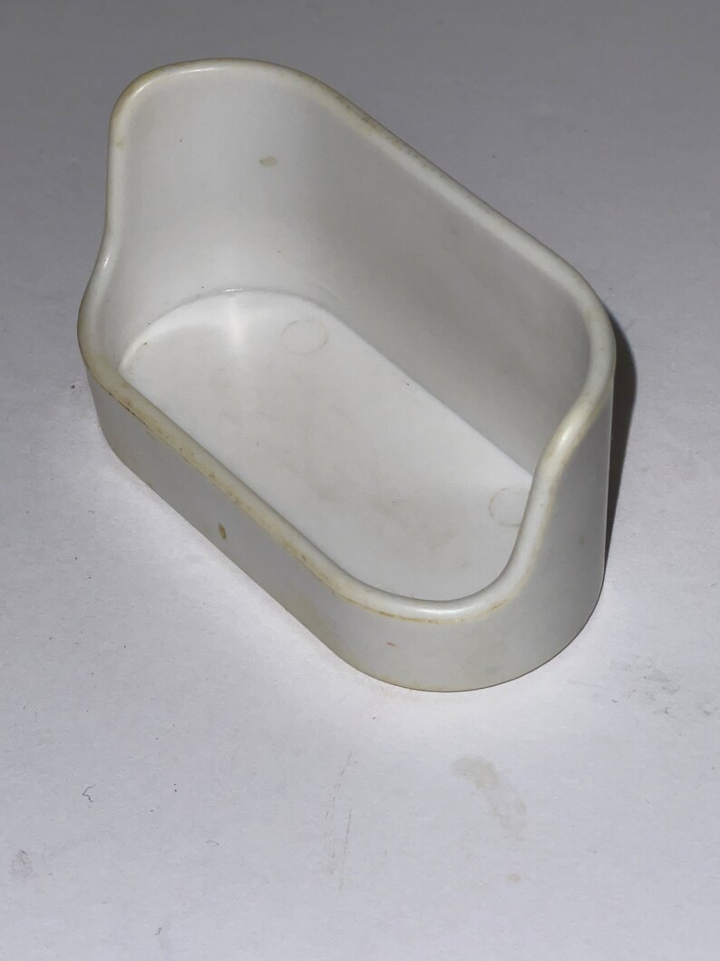 Puede incluir: Un juguete de ba&ntilde;o de pl&aacute;stico blanco para ni&ntilde;os. La ba&ntilde;era es peque&ntilde;a y tiene una forma redondeada.