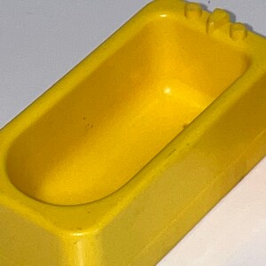 Może przedstawiać: Ż&oacute;łta plastikowa wanna do zabawy dla dzieci. Wanna wykonana jest z gładkiego, twardego plastiku i ma lekko zaokrąglony kształt.