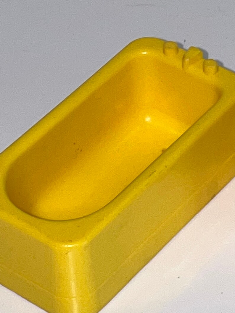 Może przedstawiać: Ż&oacute;łta plastikowa wanna do zabawy dla dzieci. Wanna wykonana jest z gładkiego, twardego plastiku i ma lekko zaokrąglony kształt.