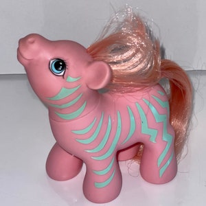 May include: Pink My Little Pony with a blue and white zebra stripe pattern. The pony has a pink mane and tail.