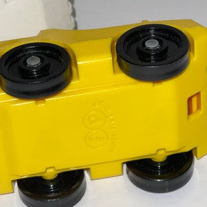 May include: Yellow toy car with black wheels and a Fisher-Price logo on the bottom.