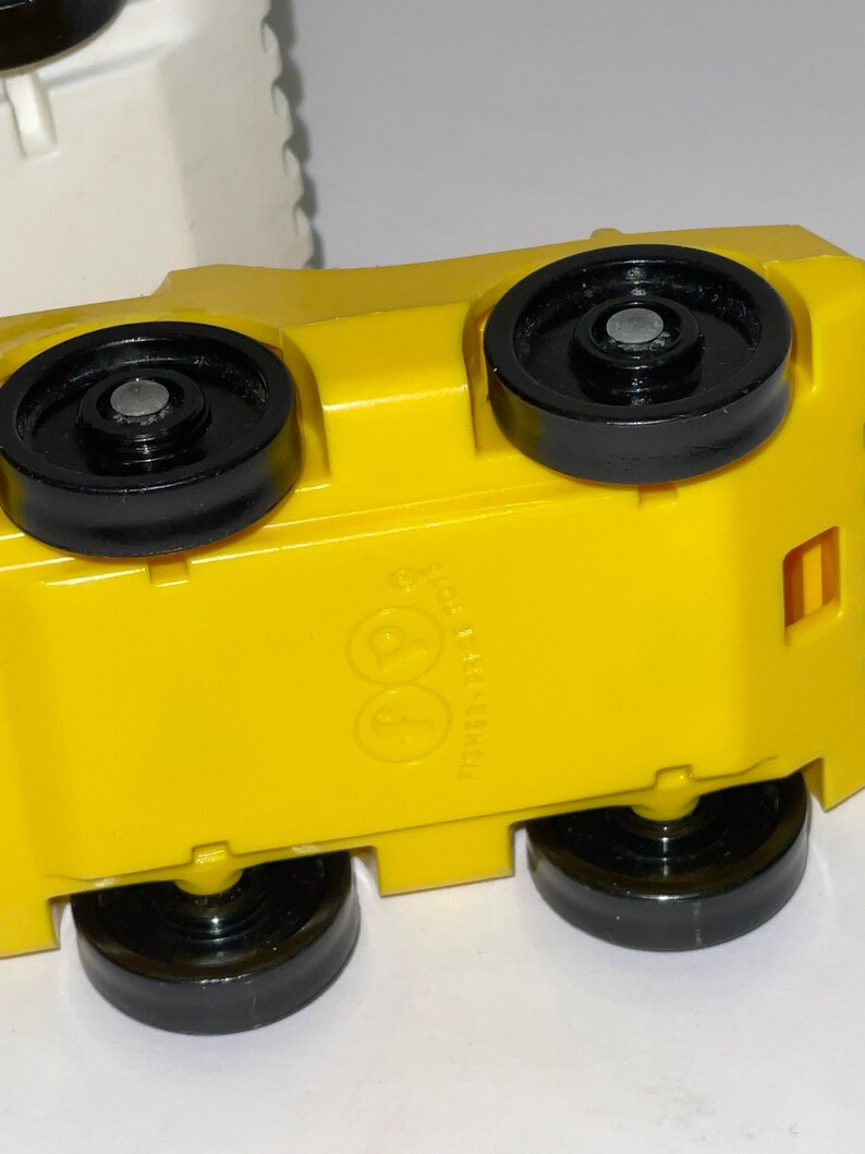 May include: Yellow toy car with black wheels and a Fisher-Price logo on the bottom.