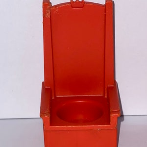 May include: A red plastic throne chair with a crown on the back. The chair has a small seat and four legs.