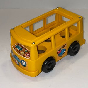 May include: A yellow plastic toy school bus with black wheels and a "BUS" sign on the side. The bus has windows and a door, and there are four empty seats inside.