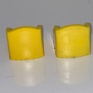 May include: Two yellow plastic chairs with a rounded back and a simple design.