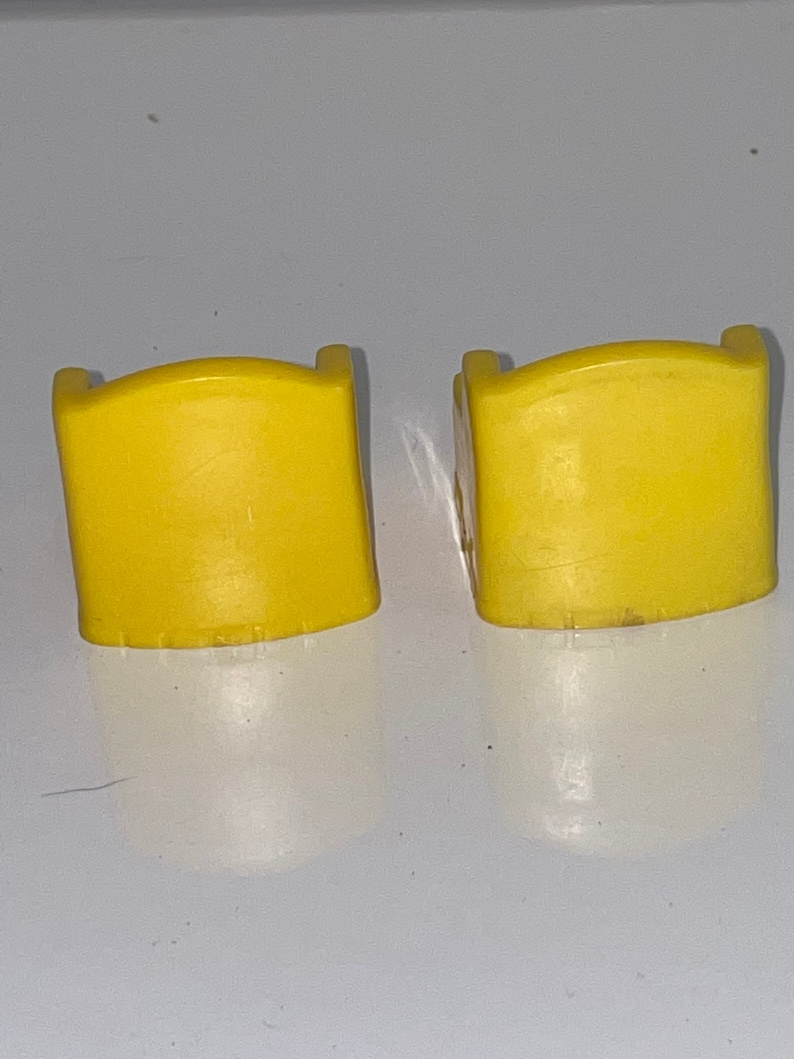May include: Two yellow plastic chairs with a rounded back and a simple design.