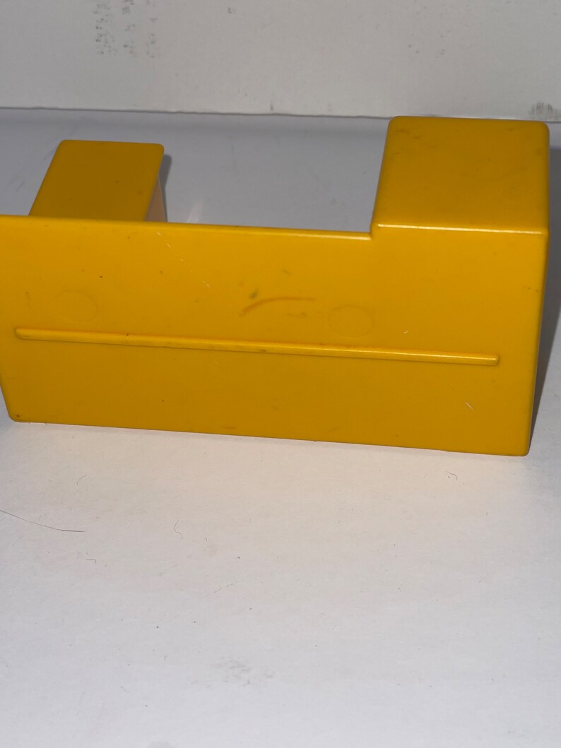 K&ouml;nnte beinhalten: Ein gelber Plastikspieltisch mit einem kleinen Stuhl auf der linken Seite und einem gr&ouml;&szlig;eren Stuhl auf der rechten Seite.