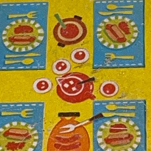 Pu&ograve; includere: Una tavola apparecchiata con tovagliette azzurre, piatti rossi e bianchi e una ciotola rossa con un cucchiaio. Ci sono anche quattro piccole ciotole rosse con puntini bianchi sul tavolo.