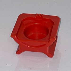 May include: A red plastic toy throne with a round seat and a crown on top.