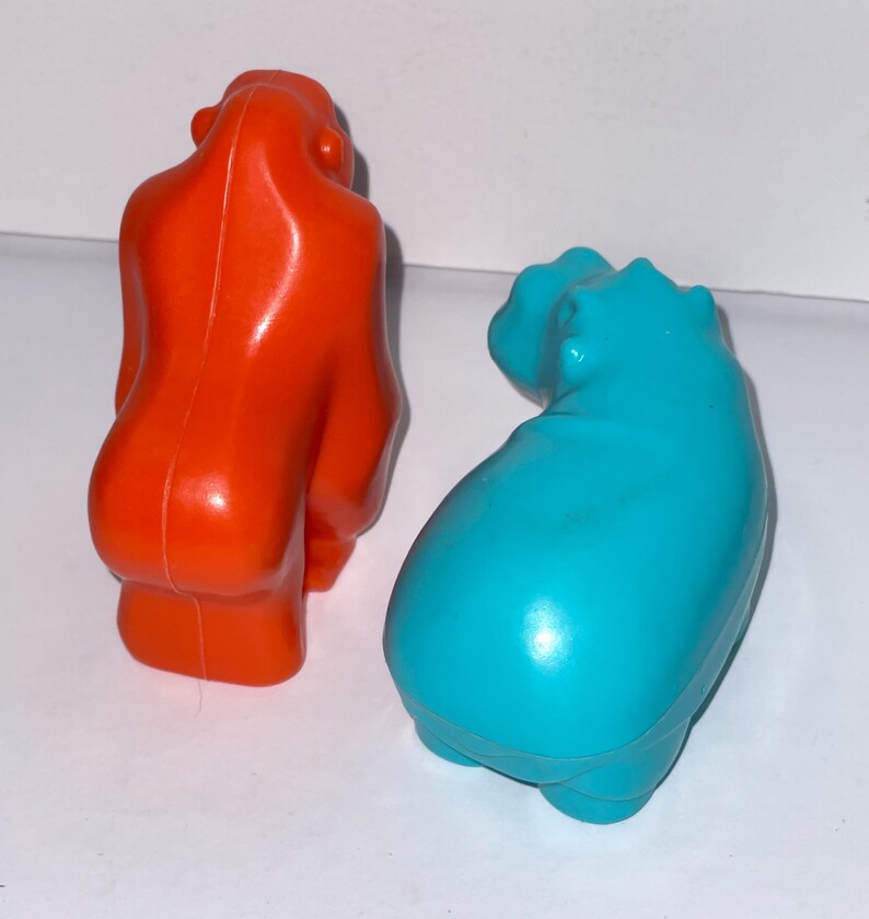 May include: Two plastic animal figurines, a bright orange gorilla and a turquoise blue hippopotamus.