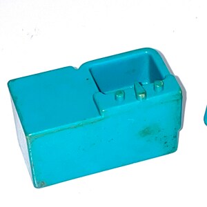 May include: A turquoise blue plastic toy kitchen sink with a countertop and three knobs.