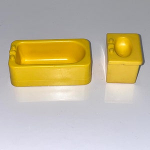 Może przedstawiać: Ż&oacute;łty plastikowy zestaw wanny i umywalki do domku dla lalek. Wanna ma zaokrąglone dno, a umywalka ma okrągłą misę.