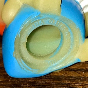 Puede incluir: Primer plano de un juguete de pl&aacute;stico azul y amarillo con las palabras "CHINA &copy; 1987" impresas en la parte inferior.