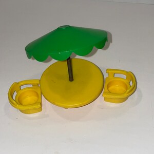 May include: A yellow plastic table and two chairs with a green umbrella. The table and chairs are designed for small children.