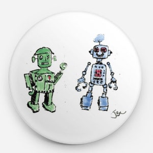 May include: A white button with a green and blue robot illustration. The green robot has a round head with a single eye and a small antenna. The blue robot has a round head with two eyes and a small antenna. The robots are both smiling.