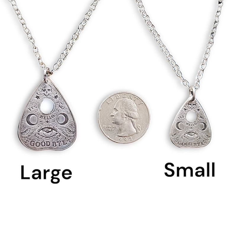 Two silver necklaces with a Ouija board planchette pendant. The larger pendant is larger than the size of a quarter. The smaller pendant is about the size of a quarter. The necklaces are on a white background.