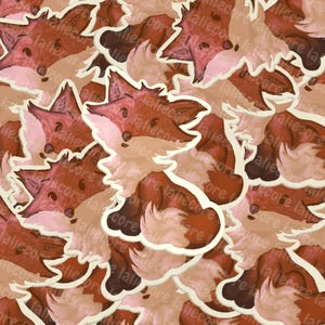 Peut inclure: Motif répété d'autocollants de renards de dessin animé. Les renards ont une fourrure rousse et brune avec des accents blancs et roses. Les autocollants ont une bordure blanche et sont dispersés sur un fond brun clair. Le mot "aliecore" est imprimé sur les autocollants.