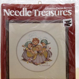 May include: Needle Treasures counted cross stitch kit featuring a circular design of four children in traditional clothing, titled "Ring Around the Rosie" by M.I. Hummel. The kit includes 14 count Aida fabric, 100% cotton floss, a needle, and instructions. The finished size is 10 inches in diameter.