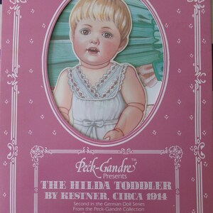 May include: A pink paper doll booklet featuring a vintage Hilda Toddler doll by Kestner, circa 1914. The booklet includes 12 authentic fashions for the doll.