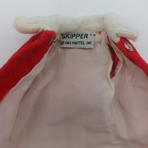 May include: Red and white doll coat with a white fur collar and a label that reads "SKIPPER T.M. &copy; 1963 MATTEL, INC."