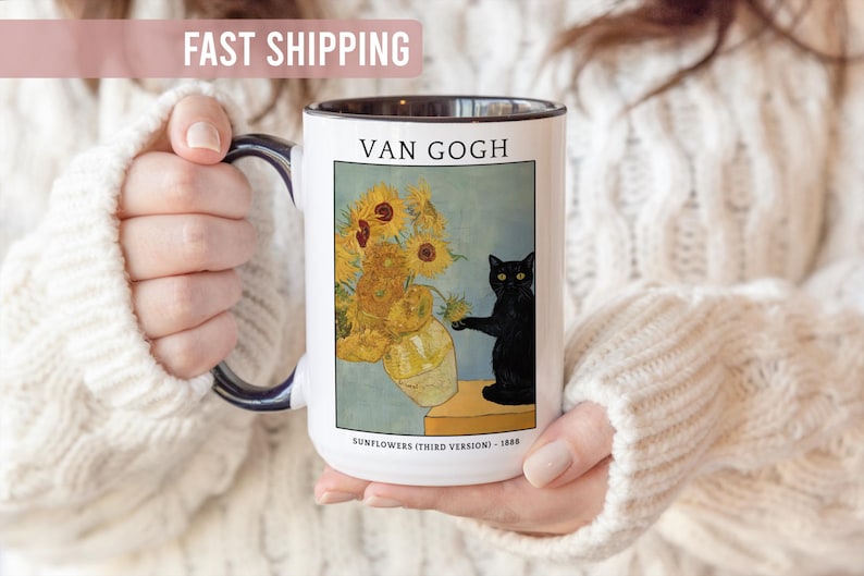 May include: White ceramic mug featuring a print of Van Gogh's "Sunflowers" painting with a black cat. The mug has a black interior and handle. Text on the mug reads "VAN GOGH" and "SUNFLOWERS (THIRD VERSION) - 1888".