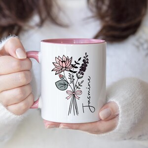 May include: A set of three ceramic mugs with a speckled, matte finish. The mugs are in shades of cream, light gray, and dark gray. Each mug has a simple, minimalist design and a rounded handle.