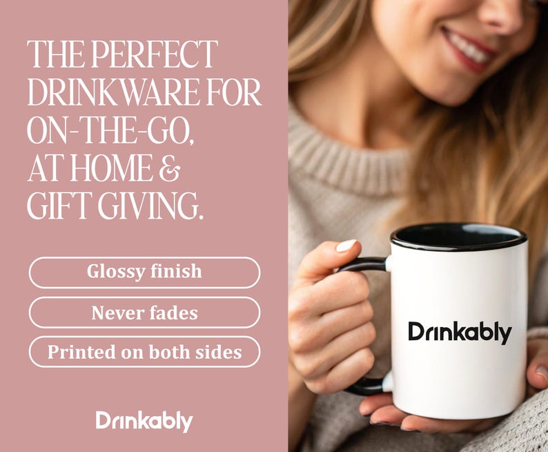 May include: A white mug with a black interior and handle, featuring the word "Drinkably" in black. The mug is held by a person. The image also includes text that says "Glossy finish", "Never fades", and "Printed on both sides".