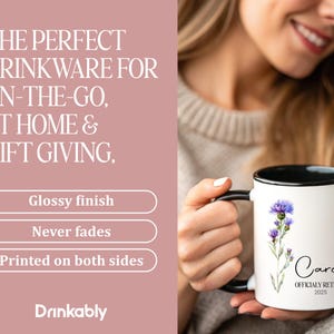 May include: White ceramic mug with a black rim and handle, featuring a watercolor thistle design and the name "Carol" with "OFFICIALLY RETIRED 2025." The mug has a glossy finish and is printed on both sides.