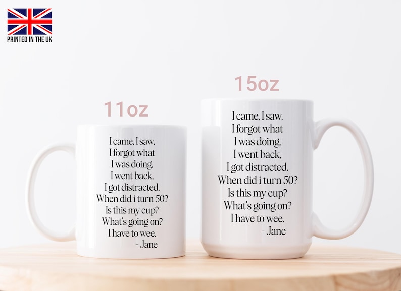 May include: Two white ceramic mugs, 11oz and 15oz, with a humorous quote printed in black. The text includes phrases like "I came, I saw, I forgot what I was doing." The mugs are on a light wooden surface.