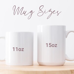 May include: Two white ceramic mugs of different sizes are displayed on a wooden surface. The smaller mug is labeled "11oz" and the larger mug is labeled "15oz". The text "Mug Sizes" is written above the mugs in a cursive font.