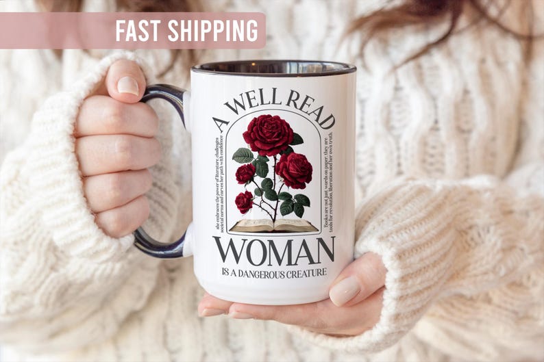 May include: White ceramic mug with a black handle and rim. The mug features a design with red roses, an open book, and the text "A Well Read Woman Is A Dangerous Creature."