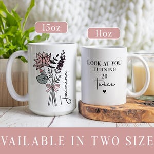 May include: A white ceramic mug with a black handle and the text "But First, Coffee" in a black, bold font. The mug is sitting on a wooden surface. The mug is approximately 4 inches tall.