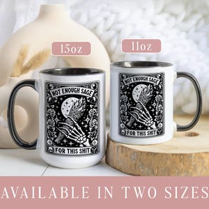 May include: Two white ceramic mugs with black handles and rims. Each mug features a black and white graphic with the text "NOT ENOUGH SAGE FOR THIS SHIT." One mug is labeled 15oz, the other 11oz. Available in two sizes.