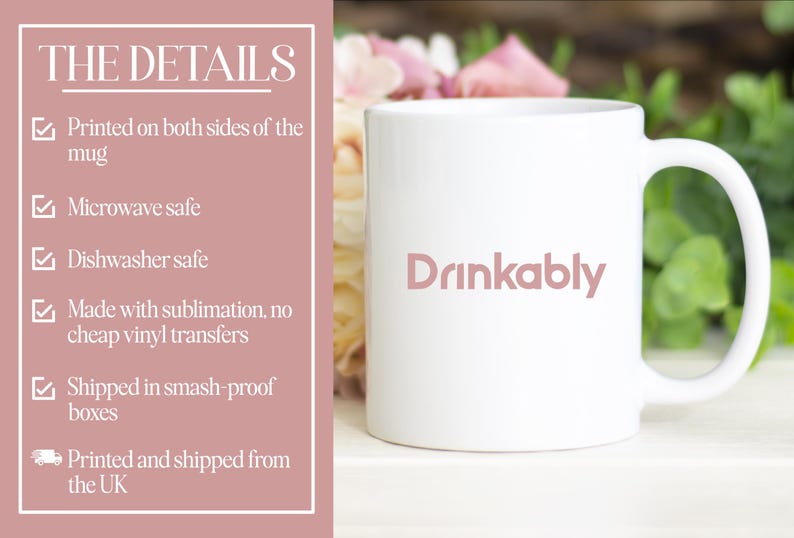 May include: White ceramic mug with the word "Drinkably" in a soft pink font. The mug has a curved handle and is set against a backdrop of flowers and greenery. The mug is microwave and dishwasher safe.