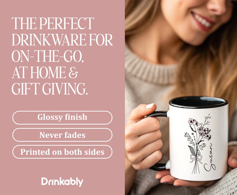 May include: White ceramic mug with a black interior and handle, featuring a floral design and the name "Susan." The mug is held by a person. Text on the left reads "The perfect drinkware for on-the-go, at home & gift giving."