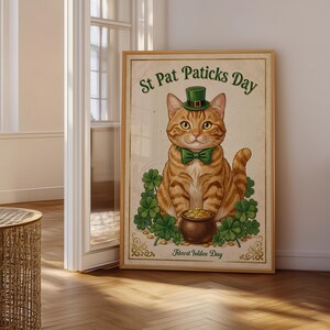 May include: A framed poster featuring an orange tabby cat wearing a green top hat and bow tie. The cat sits behind a pot of gold coins surrounded by green shamrocks. The text reads St Pat Paticks Day at the top and Filevst Iolilee Day at the bottom.